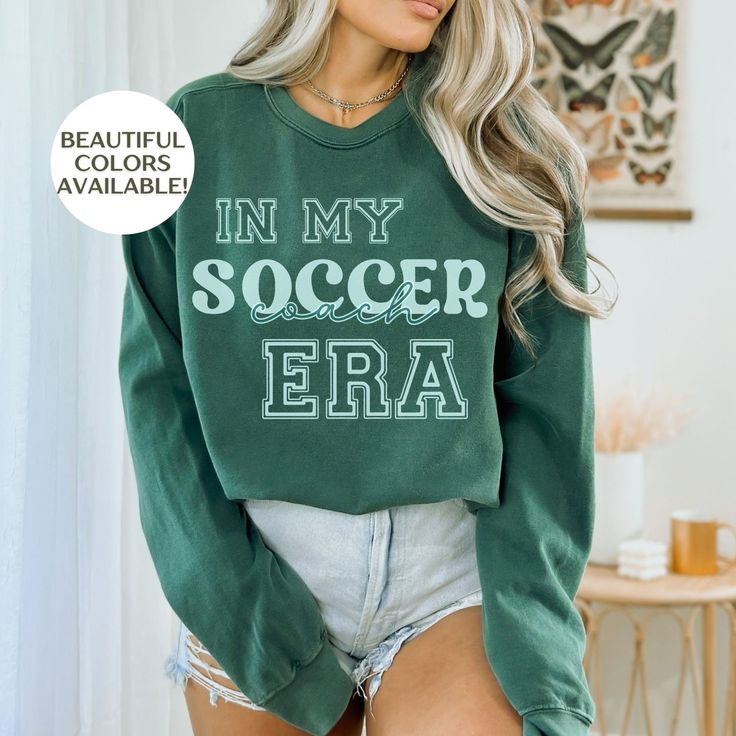 This personalized soccer sweatshirt is the perfect soccer gift for soccer mom, soccer coach, soccer aunt, etc. Customize this shirt to fit your needs. This is the perfect long sleeve soccer game day shirt to cheer up any game! 𝐃𝐄𝐓𝐀𝐈𝐋𝐒  🌟Unisex Crewneck Sweatshirt  🌟100% ring-spun cotton threads for unmatched softness 🌿  🌟Light fabric (6.4 oz/yd² or 217 g/m²)  🌟Relaxed fit for extra comfort  🌟Printed with eco-friendly dyes ✨ Incredible Quality 🌱 Environmentally Friendly 🌱 Sustainab Green Sweatshirt With Letter Print For Fans, Personalized Crew Neck Sports Top, Personalized Crew Neck Tops For Fan Merchandise, Personalized Sporty Tops For Sports, Sporty Personalized Tops For Sports Events, Casual Personalized Tops For Game Day, Preppy Soccer, Coach Soccer, Soccer Sweatshirt