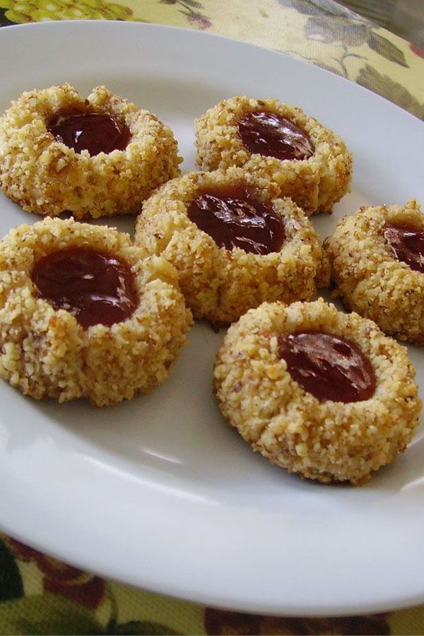 several cookies with jam on them sitting on a white plate