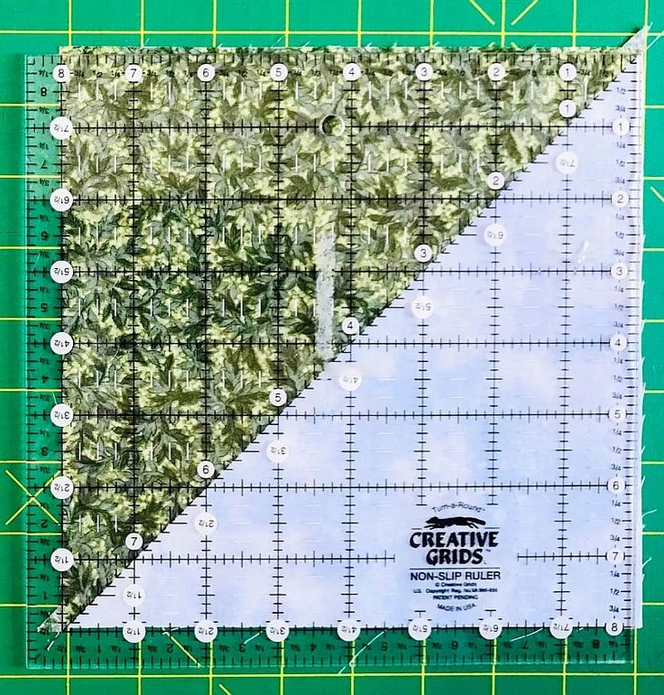 a green and white cutting mat with a ruler on it that says creative grids