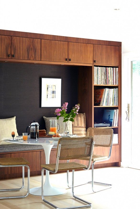 a dining room table with chairs and bookshelf in the backround area