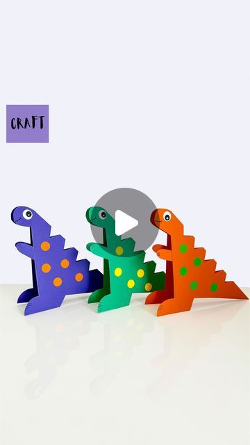 three colorful toy dinosaurs standing in the shape of letters that spell out'q '