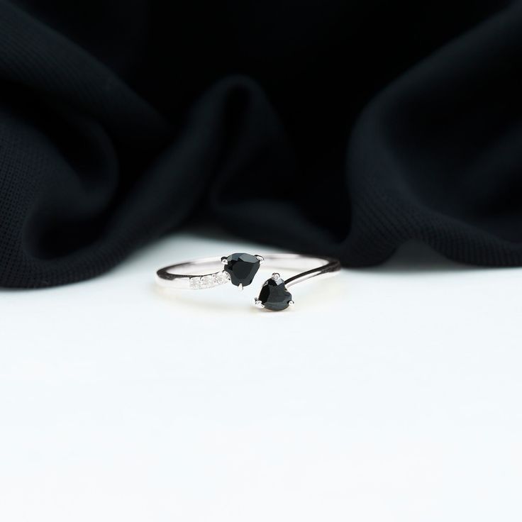 Product Details Celebrate the timeless bond of two hearts entwined with the utmost beauty in our Romantic Black Onyx Heart Promise Ring. Two exquisite Heart Shape Black Onyx stones, delicately cradled in a Claw Setting, symbolize your union and grace her heart with a touch of opulence. A line of petite Round Shape Diamonds on one side adds a dazzling contrast, shimmering along the band. This Wrap Ring elegantly embraces the finger, earning its place as a modern-day classic, a heartfelt and luxur Hearts Entwined, Heart Promise Rings, Claw Setting, Stone Wrapping, Black Onyx Stone, Wrap Ring, Ring With Diamond, 18k Yellow Gold Ring, Two Hearts