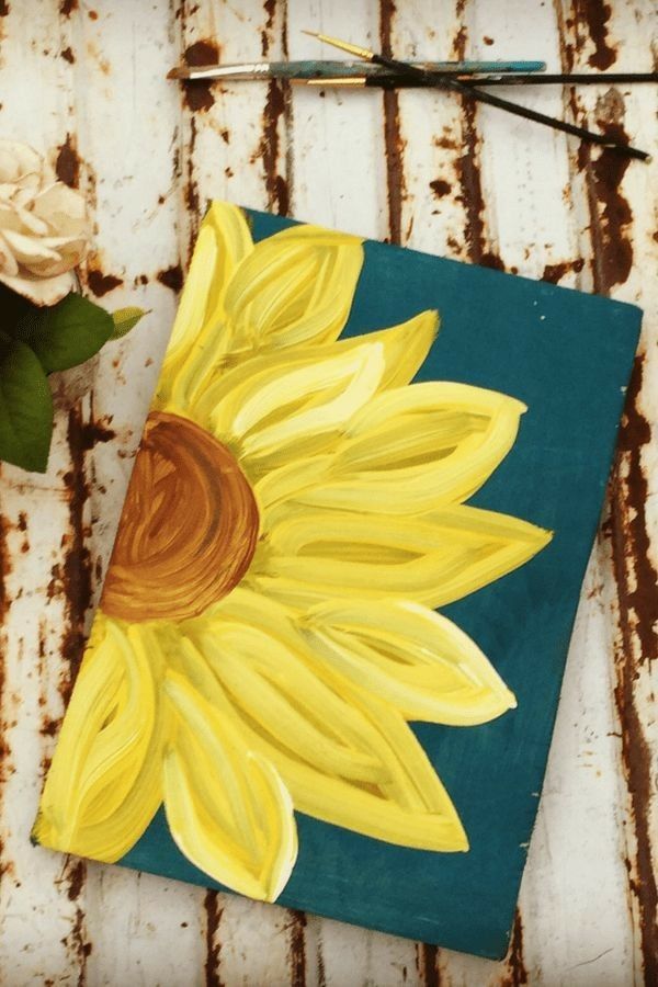 a painting of a sunflower on a piece of wood