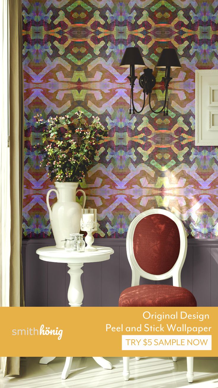 a chair and table in front of a wallpapered background with flowers on it