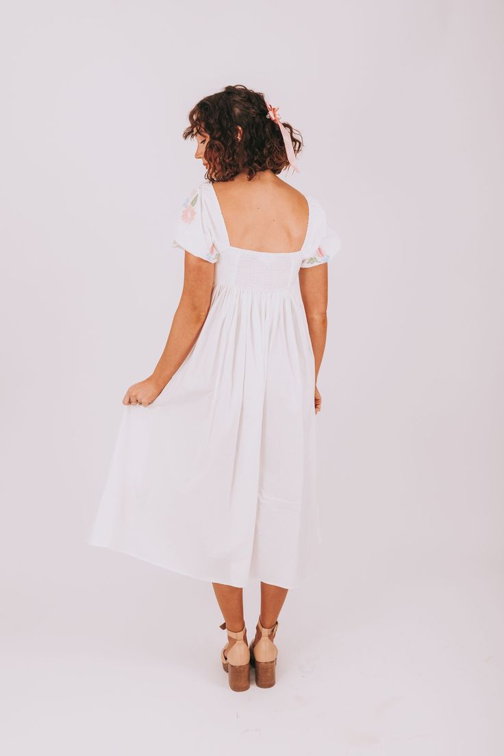 the back view of a woman wearing a white dress