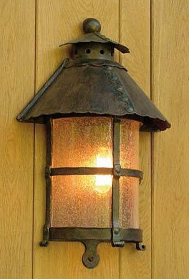 a light that is on the side of a wall next to a wooden door with wood paneling