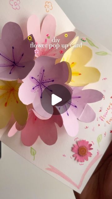 someone is holding up a card with paper flowers on it and the words, flower pop up card