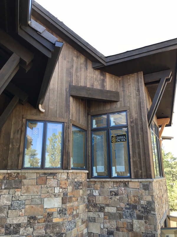 the side of a house with stone and wood siding