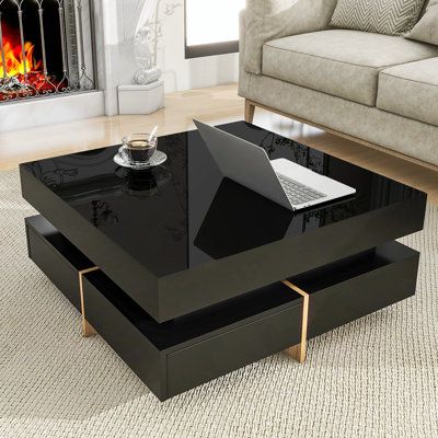 a black coffee table with a laptop on it