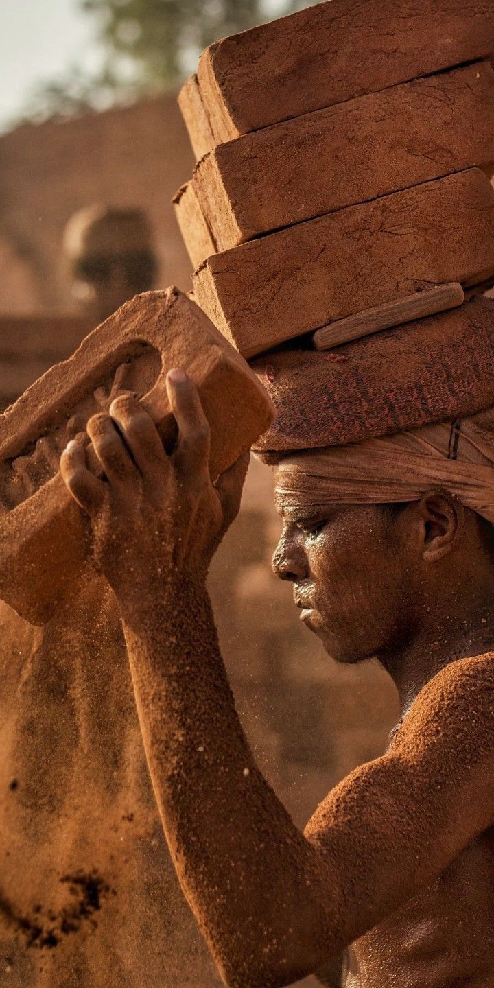 a man is carrying bricks on his head