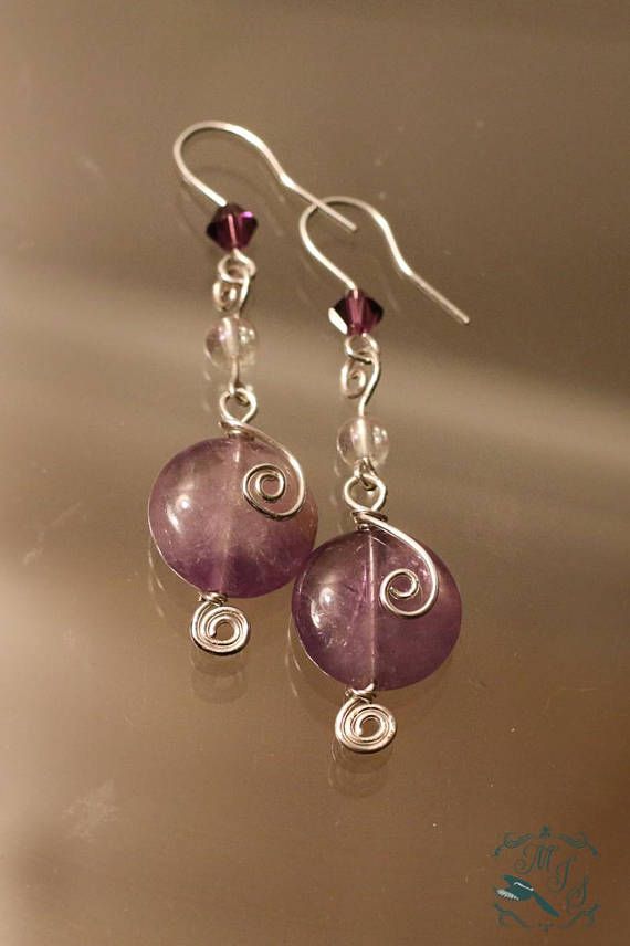 the earrings are made out of glass and wire with purple beads on each earwire