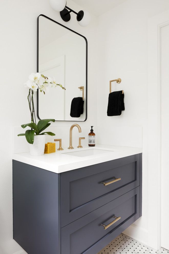 a bathroom with a sink, mirror and flowers in the vase on the counter top