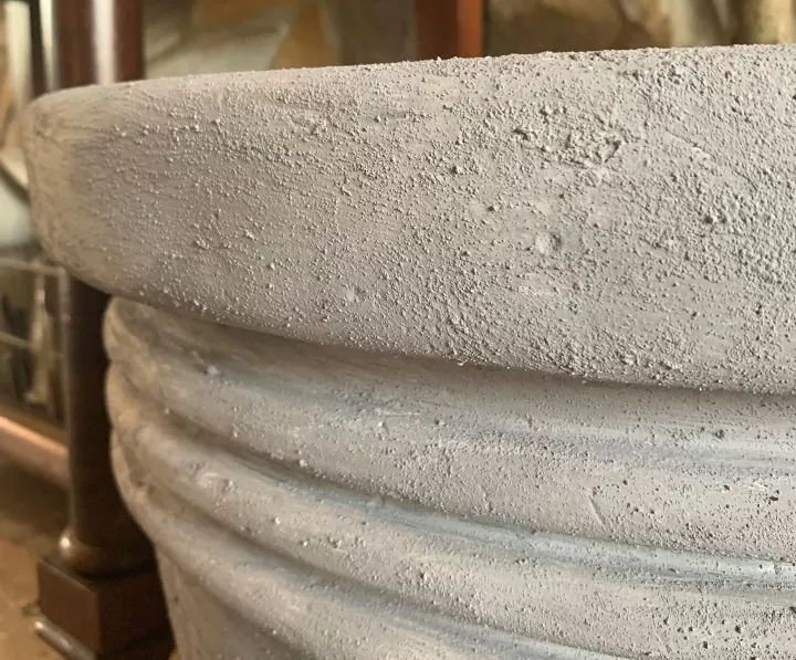 a close up of a cement planter on a table