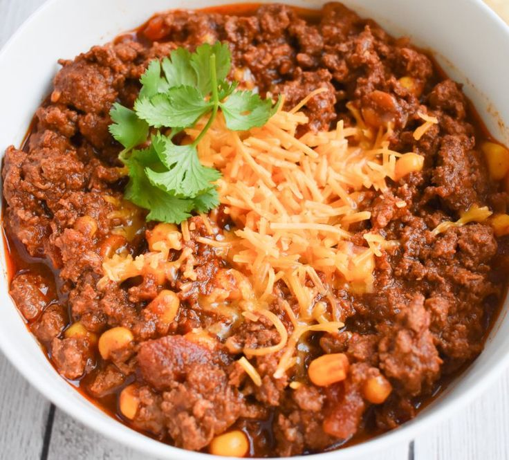 a white bowl filled with chili and cheese