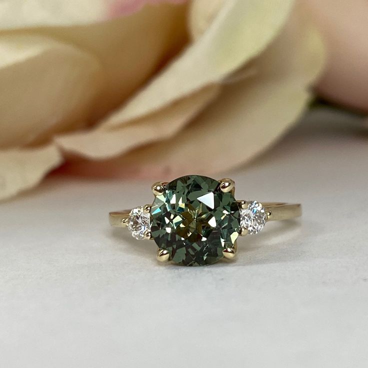 a close up of a ring with a flower in the background