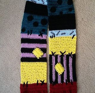 a pair of colorful crocheted socks laying on top of a carpeted floor