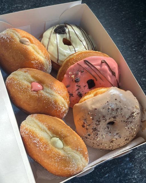 a box filled with lots of different flavored donuts