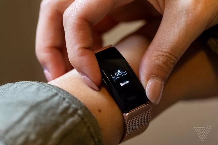 a close up of a person holding a smart watch on their wrist and touching the screen