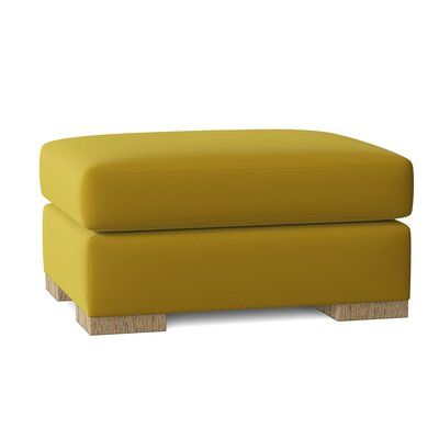 a yellow ottoman sitting on top of a white floor