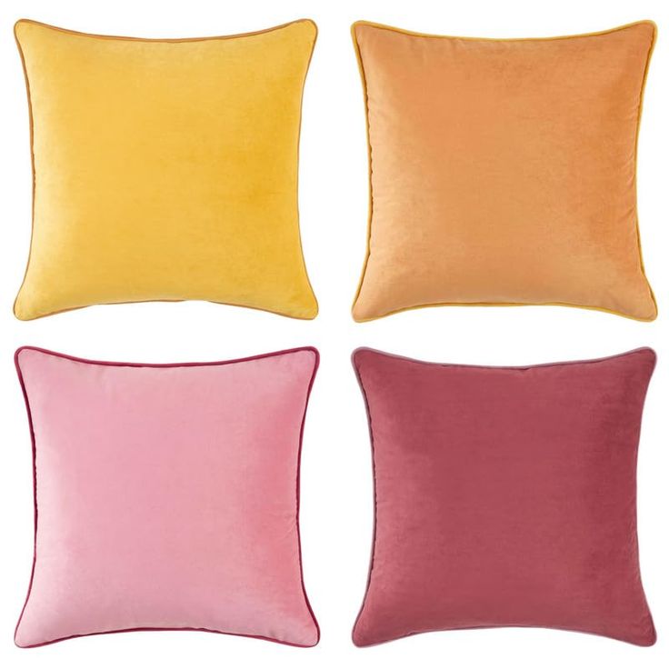 four different colored pillows on a white background