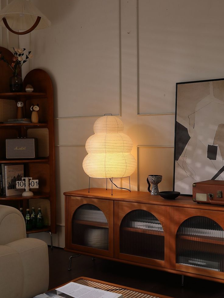 a living room with a couch, table lamp and bookcase in the corner next to it