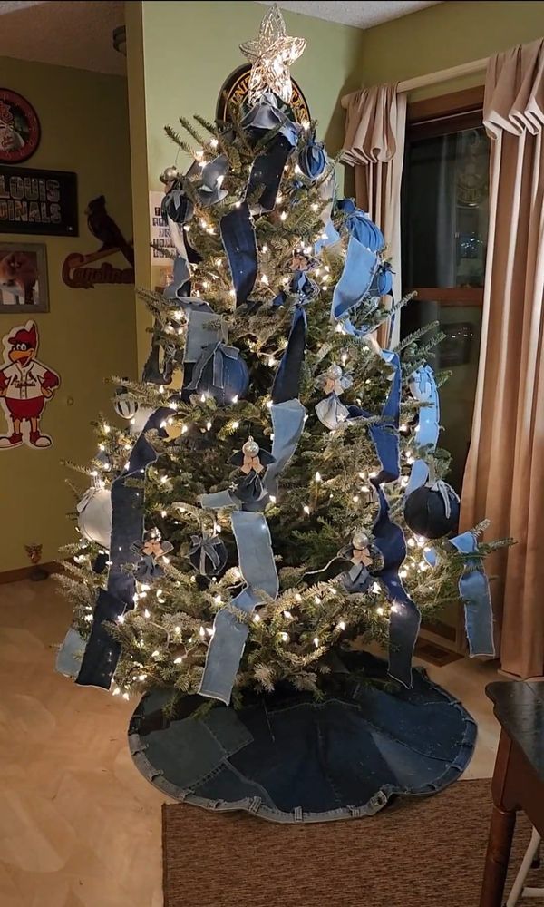 a decorated christmas tree with blue ribbon and lights