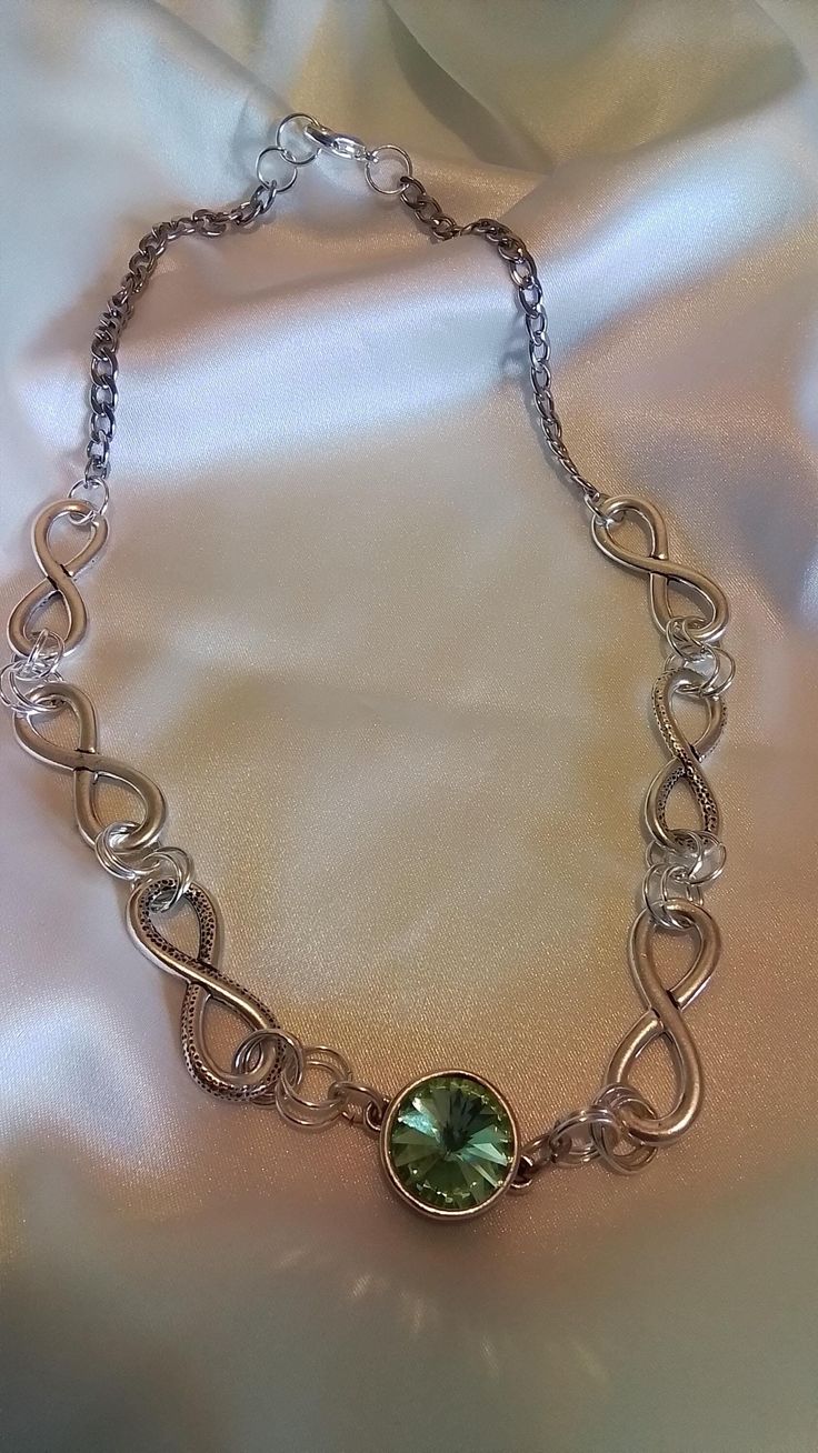 A Dazzling necklace made up of antique pewter links form an interesting design showcasing a peridot crystal at center to add some pizzaz. This infinity chain  of large links is lightweight and finished with a sturdy stainless silver chain...  The center is a peridot green crystal gem encased in a filigree design base.it measures 18 inches. Ready to send to you. And it ships free Silver Chain Link Jewelry For Party, Metal Link Jewelry With Silver Chain, Silver Chain Link Metal Jewelry, Silver Chain Link Jewelry, Alloy Chain Link Jewelry Gift, Nickel-free Silver Infinity Jewelry, Alloy Link Chain Jewelry, Silver Metal Chain Necklace As Gift, Silver Metal Chain Necklace For Gift