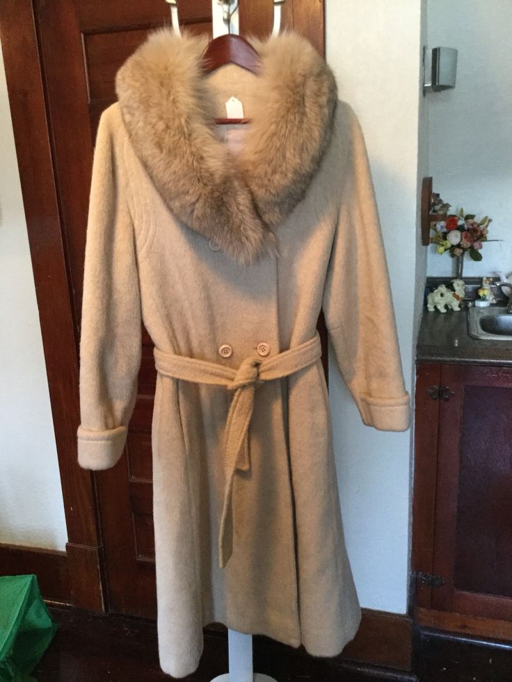 This is just a beautiful women's double breasted coat with a classic shape in a lovely soft beige colour. The coat, made by Sterling Stall, is made of a wool blend with a faux fur collar. It has a belt, cuffs on the sleeves,  two outer pockets and stitching detail around the yoke. It is fully lined. The measurements, taken with the coat lying flat, are: shoulder to shoulder, 17 inches; armpit to armpit, 19 1/2 inches; sleeves, 24 inches; overall length, 46 inches; sweep, 44 inches. About women's size small to small medium. In excellent condition. Beige Fitted Shawl Collar Outerwear, Fitted Beige Outerwear With Shawl Collar, Chic Beige Wool Fur Coat, Cream Pea Coat For Winter, Fitted Beige Pea Coat For Winter, Cream Double-breasted Wool Coat For Winter, Cream Double-breasted Pea Coat For Winter, Winter Wool Fur Coat In Beige, Beige Wool Fur Coat For Winter