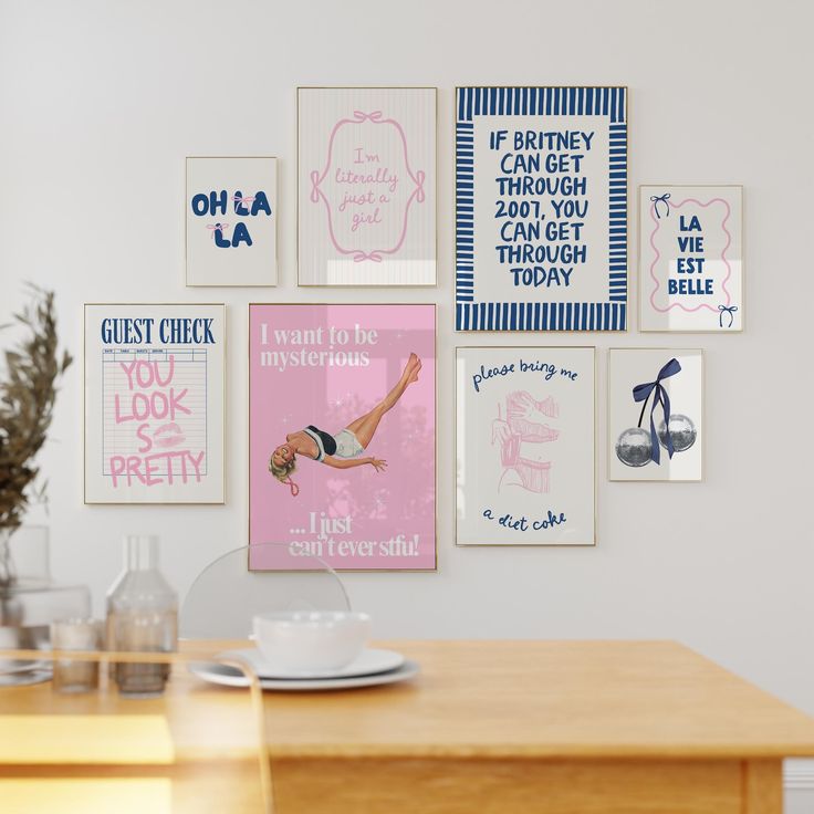 a wooden table with plates and cups on it in front of a wall full of posters