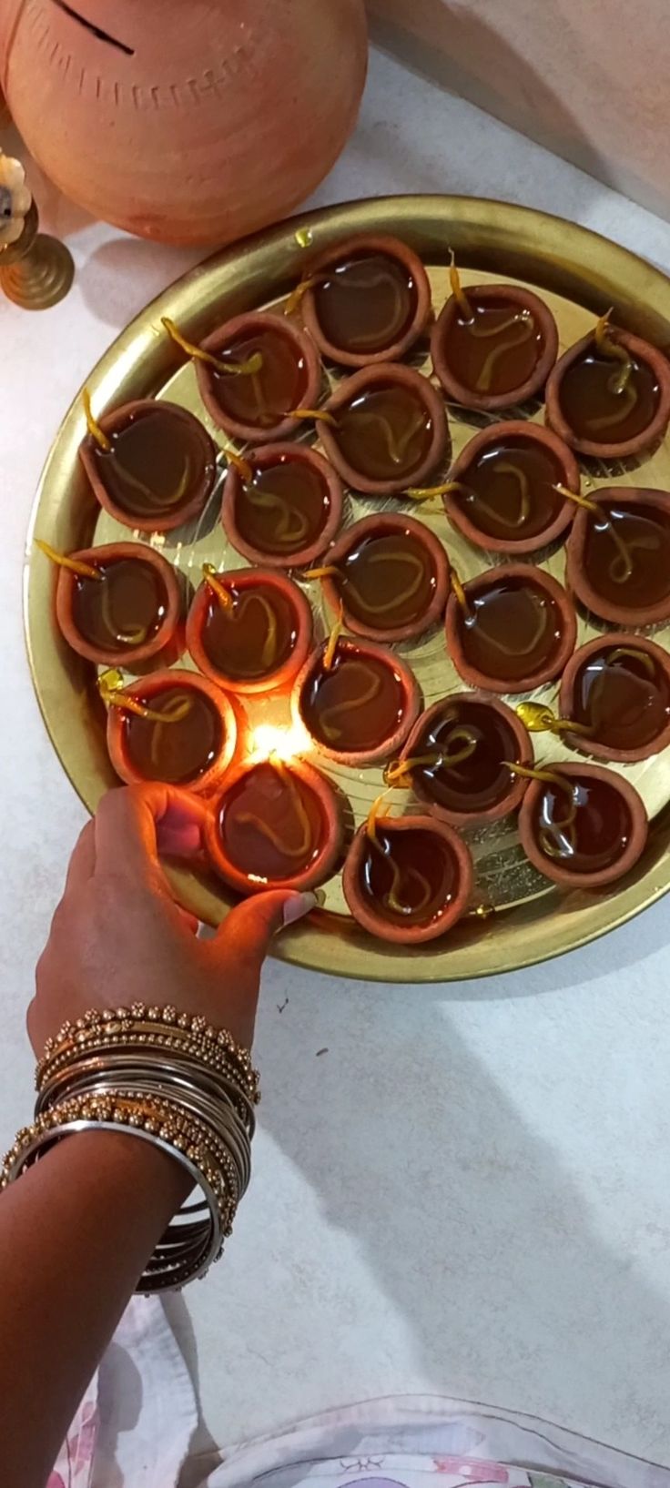 a person holding a plate with some kind of food on it and lit candles in the middle