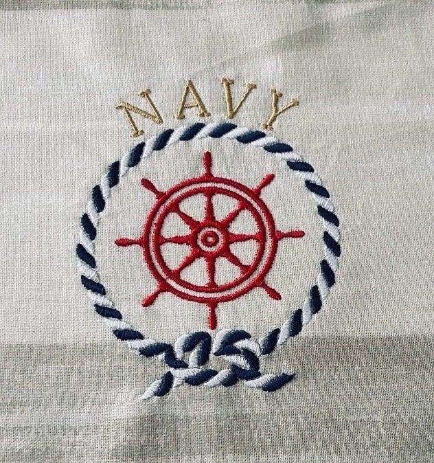 an embroidered sailor's wheel with the word navy on it