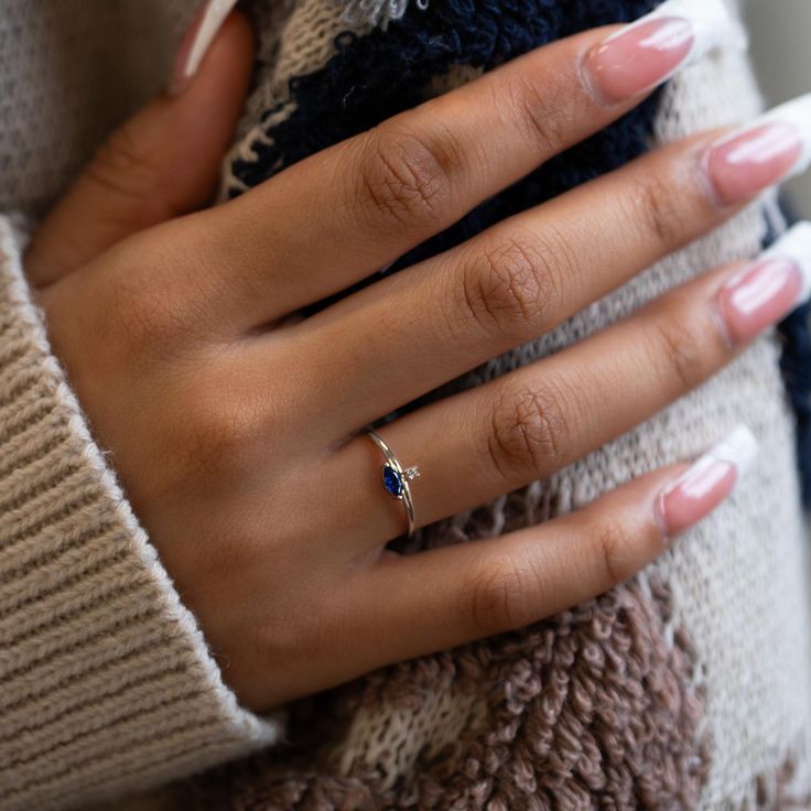 Abstract and minimal, this dainty ring features a tiny round stone paired with a sideways Sapphire Blue Marquise stone. Great gift for September Birthdays! .925 Sterling Silver Cubic Zirconia crystals Hypoallergenic. Lead and nickel free Round 1.5mm, Marquise H 3mm x W 6mm Band Ring Thickness 1.5mm #R112 Dainty Cubic Zirconia Birthstone Ring With Prong Setting, Minimalist Crystal Diamond Ring With Birthstone, Minimalist Diamond Birthstone Crystal Ring, Dainty Sapphire Birthstone Ring For Promise, Dainty Cubic Zirconia Crystal Birthstone Ring, Dainty Gemstone Midi Rings, Dainty Promise Birthstone Ring, Dainty Sapphire Ring With Prong Setting, Dainty Cubic Zirconia Sapphire Promise Ring