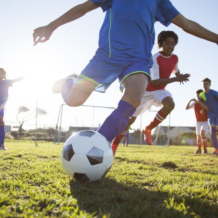 young children playing soccer on the field