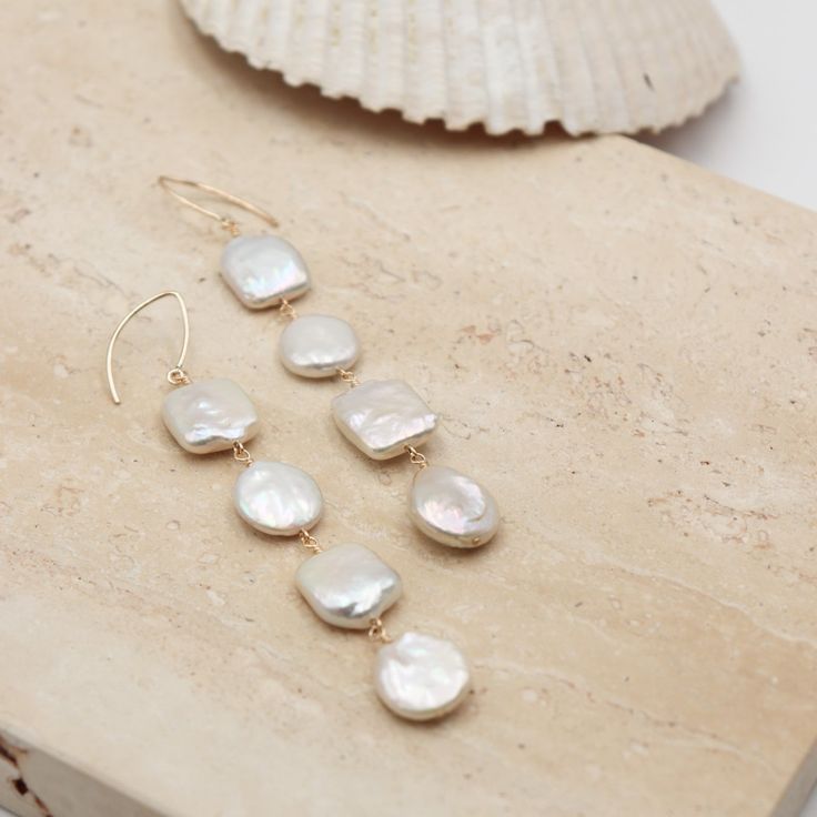 Perfect for adding a touch of elegance to any outfit. Crafted with high-quality luster pearls in both coin and square styles, these earrings radiate beachy and wedding vibes. Each pearl is meticulously hand-wrapped in 14K gold-filled wire, ensuring both beauty and durability. Elevate your summer style or accessorize for special occasions with these gorgeous dangles. - 14K Gold Filled- Freshwater Pearls- Coin and Square Styles Elegant Summer Wedding Pearl Earrings, Elegant Pearl Charm Earrings For Summer, Elegant Summer Pearl Earrings With Pearl Charm, Elegant Pearl Earrings With Pearl Charm For Summer, Elegant Summer Pearl Earrings, Elegant Gold Pearl Earrings For Summer, Summer Wedding Jewelry With Pearl Charm, Summer Wedding Pearl Charm Jewelry, Elegant Pearl Earrings For The Beach