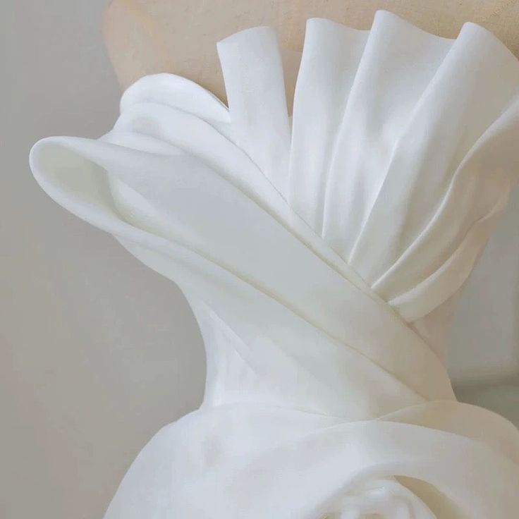 the back of a white dress on a mannequin's headdress