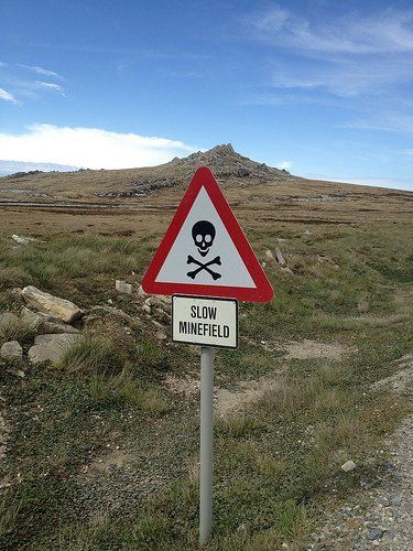 a road sign with a skull and crossbone on it in the middle of nowhere