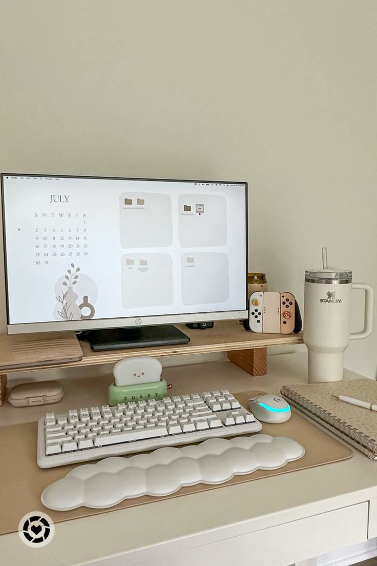 a computer monitor sitting on top of a desk next to a keyboard and mouse pad