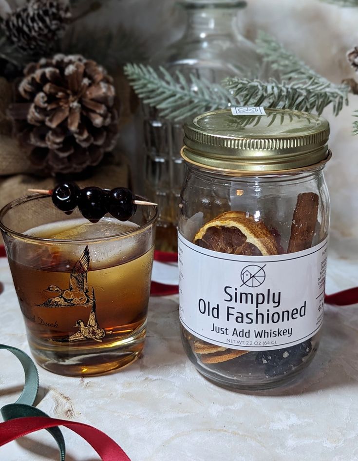 an old fashioned glass jar filled with cinnamon and black olives next to a christmas decoration