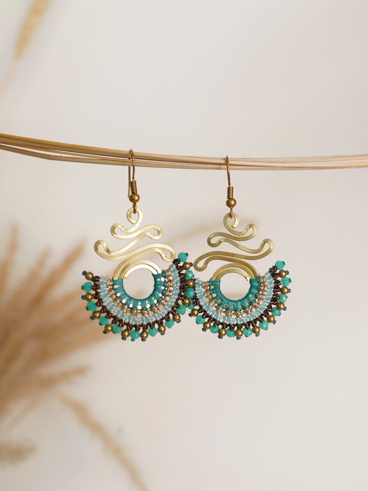 Handmade Macrame Crystal Brass Earrings, featuring an ethnic Boho Bohemian fan spiral design. These chic teardrop earrings are the perfect gift, adding a touch of elegance to any outfit.  Crafted with care and attention to detail, they blend Bohemian flair with timeless sophistication. Whether she's dressing up for a special occasion or adding a stylish accent to her everyday look, these earrings are sure to become a treasured piece in her collection. Give her the gift of exquisite craftsmanship and style with these beautiful earrings. Explore the beauty of handmade craftsmanship and elevate your style with these unique pieces. Shop now and spread the joy of Thailand Handmade Jewelry! 🌟 Weight: 7 grams/pair *If you are not sure about the size please feel free to contact me I would be happ Handmade Artisan Spiral Earrings, Handmade Spiral Earrings For Beach, Bohemian Turquoise Earrings With Ear Wire, Bohemian Turquoise Beaded Earrings With Brass, Turquoise Bohemian Earrings With Ear Wire, Bohemian Turquoise Beaded Earrings In Brass, Bohemian Turquoise Beaded Brass Earrings, Bohemian Turquoise Beaded Earrings, Bohemian Handmade Round Chandelier Earrings