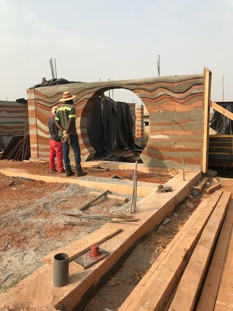 two men are standing on the roof of a building that is being built with wood planks