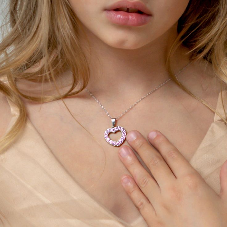 Looking for a special gift for your little princess? This gorgeous open heart pendant sparkles brightly with multiple pretty pink cubic zirconias. Crafted entirely of 925 sterling silver which is suitable for those with sensitive skin. This necklace rests on a beautiful matching link chain and comes neatly packaged in its own little gift box! Age Group: Lovely for Young Girls and Pre-Teens; Safe for Sensitive Skin Material: 925 Sterling Silver Heart Size: 17mm x 18mm Open heart, prong set (pink) Pink Heart-shaped Jewelry With Sparkling Stones, Pink Cubic Zirconia Necklaces For Mother's Day, Pink Cubic Zirconia Jewelry For Valentine's Day, Pink Sterling Silver Heart Necklace, Pink Jewelry With Sparkling Stones For Gift, Pink Sparkling Stones Jewelry For Gifts, Pink Sparkling Stones Jewelry Gift, Pink Cubic Zirconia Jewelry For Mother's Day, Pink Cubic Zirconia Heart Pendant Necklace