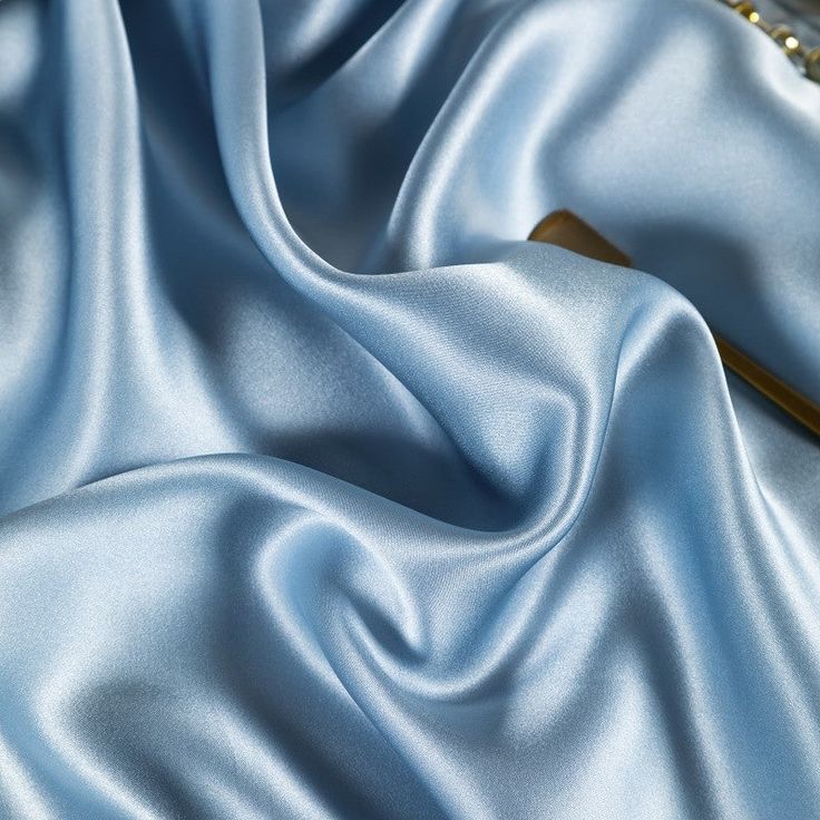 a blue satin fabric with gold beads on it