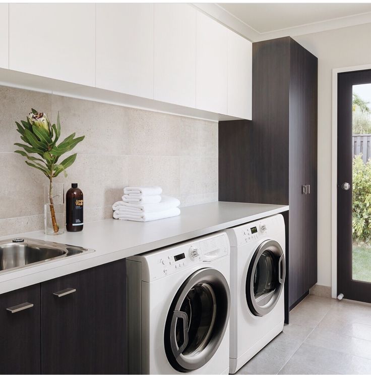 a washer and dryer sitting in a kitchen next to a door with a window