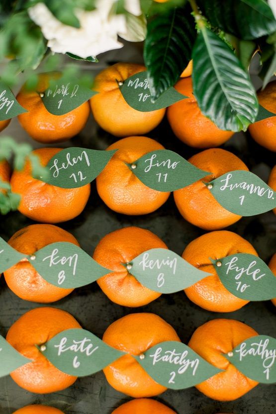 oranges for sale at an outdoor fruit stand with price tags attached to the leaves