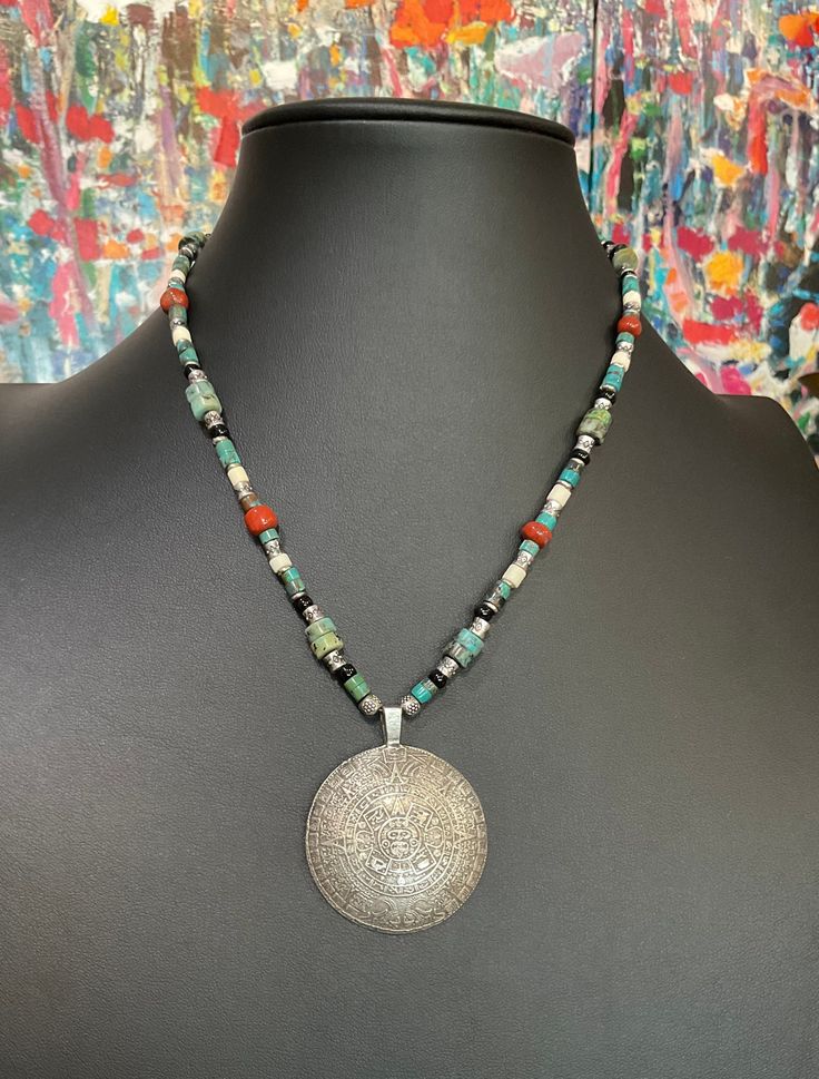 "UNISEX Fantastic genuine turquoise beaded necklace with brecciated jasper accent. Incredible extra large thick pewter Mayan Aztec calendar. . Unique pendant and design. Boho look with a southwestern feel. Versatile! Easy going and fun for daytime or evening engagements. Customization available. 18\" MaRV premium bead mix includes, but not limited to; Ancient Djenne beads, ancient African trade beads, ancient Roman glass beads, Labradorite, faceted hematite, genuine turquoise, ancient Venetian g Artisan Nickel-free Beaded Pendant Necklace, Artisan Nickel-free Pendant Beaded Necklace, Silver Beaded Turquoise Amulet Necklace, Silver Beaded Amulet Turquoise Necklace, Artisan Silver Beaded Turquoise Necklace, Spiritual Silver Turquoise Necklace With Gemstone Beads, Spiritual Turquoise Gemstone Beads Necklace, Artisan Turquoise Necklace With Silver Gemstone Beads, Silver Beaded Round Turquoise Necklace