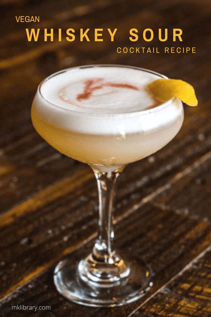 a cocktail in a coupe glass with a lemon garnish on the rim and text that reads vegan whiskey sour cocktail recipe