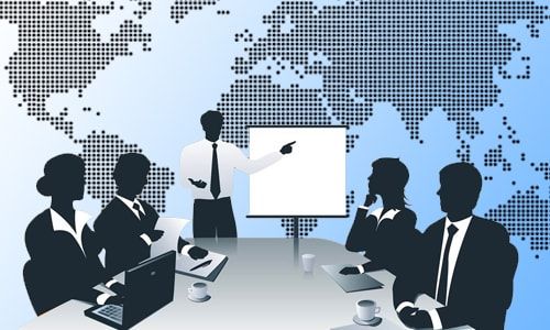 silhouettes of people sitting around a conference table with a world map in the background