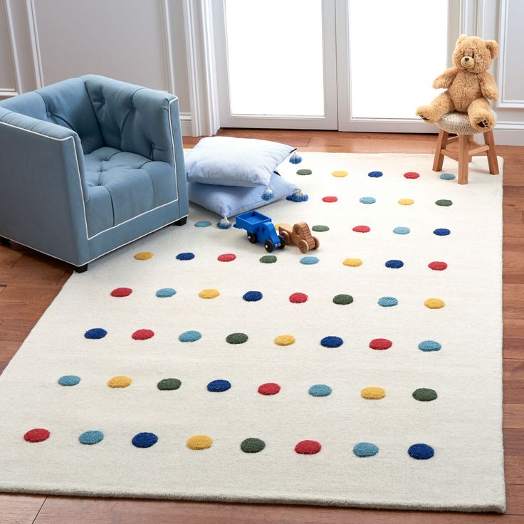 a child's room with two chairs and a rug that has colorful polka dots on it