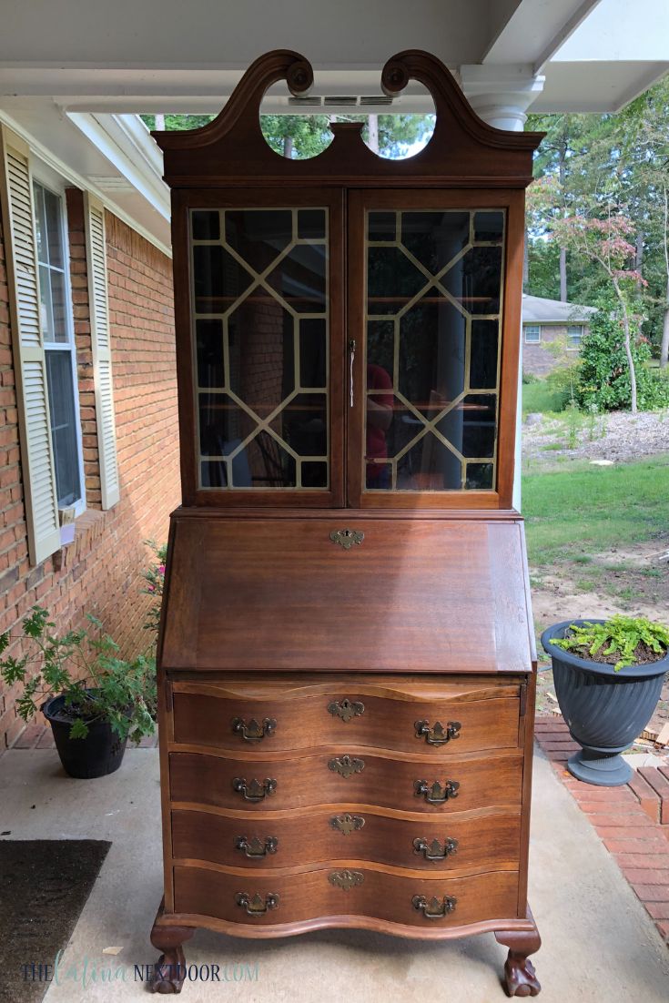 an old wooden dresser with glass doors on top