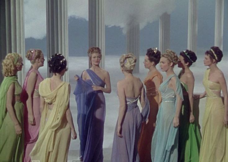 a group of women standing next to each other in dresses